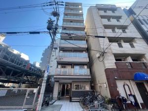 LANDMARK NAMBA EBISUCHO chan في أوساكا: مبنى طويل مع دراجات متوقفة أمامه