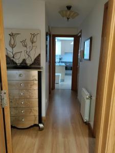 a hallway with a dresser and a hallway with a kitchen at Precioso piso proximo a Riazor in A Coruña