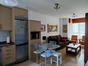 a kitchen and living room with a table and chairs at Precioso piso proximo a Riazor in A Coruña