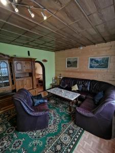 un soggiorno con divano in pelle e tavolo di Komplettes Haus mit drei Etagen und einmaligem Bergpanorama a Gehlberg