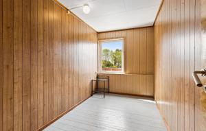 un pasillo con paredes revestidas de madera y una ventana en 5 Bedroom Cozy Home In ydegard, 
