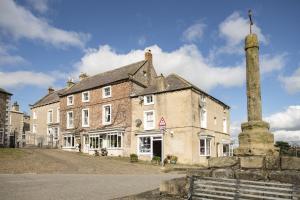 an old brick building with a chimney in front of it at Jenny Wren Cottage in Middleham