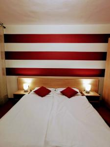 a bed in a room with a red and white striped wall at Ristorante Le Rasole in Garda