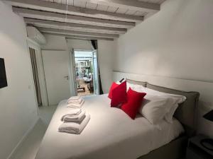 a bedroom with a white bed with red pillows at NEW Ground Floor apt and PATIO in Florence
