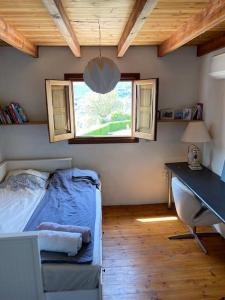 Schlafzimmer mit einem Bett, einem Schreibtisch und einem Fenster in der Unterkunft Charming Spanish Finca in beautiful nature in Málaga