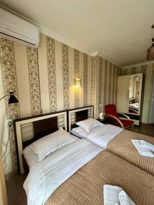1 Schlafzimmer mit 2 Betten und einem roten Stuhl in der Unterkunft Hotel Marioni in Tbilisi City