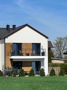 a large white house with a balcony on it at Silesia Apartments Ustron B129 in Ustroń