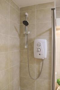 a shower with a shower head in a bathroom at Hidden Oxford Haven with Free Parking in Oxford