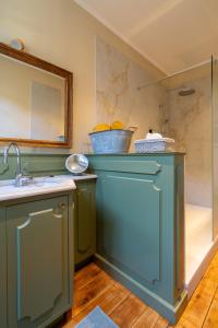 a bathroom with green cabinets and a sink at Chambre d'hôtes Conquans in Figeac