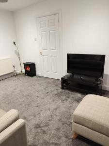 a living room with a tv and a fire place at M Rooms - entire 1 bedroom, furnished pub flat in Kirk of Shotts