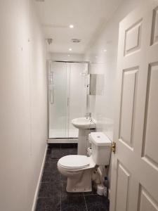 a white bathroom with a toilet and a shower at M Rooms - entire 1 bedroom, furnished pub flat in Kirk of Shotts