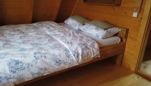 a bed in a wooden room with two pillows on it at Braća Kosorić in Han Pijesak