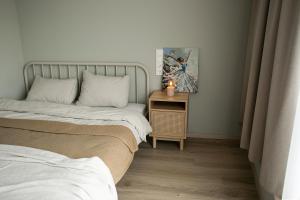 考納斯的住宿－Charming Apartment In Zeimena's Street，一间卧室配有两张床和一张带照片的桌子