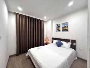 - une chambre avec un grand lit blanc et une fenêtre dans l'établissement Kaida Apartment (凯达公寓酒店), à Bắc Ninh