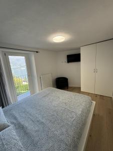1 dormitorio con cama y ventana grande en Bellano Holidays - Casa Artemio en Bellano