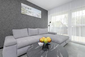 a living room with a couch and a table at Modern Apartment Close to the Beach in Gdańsk by Noclegi Renters in Gdańsk