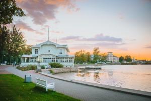 un grand bâtiment blanc à côté d'une étendue d'eau dans l'établissement Tiny Marienholm, à Haapsalu