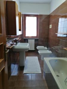 een badkamer met 2 wastafels, een bad en 2 toiletten bij maria antonietta in Urbino