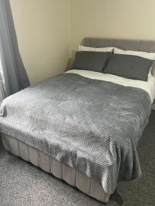 a bed with a gray comforter in a bedroom at Studio Flat 7 With Private Shower & WC in Nottingham