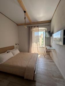 una camera con letto, finestra e televisore di Palazzo Monna B&B a Molfetta