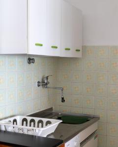 a kitchen with a sink and white cabinets at Moneglia Beach Downtown in Moneglia