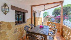 y balcón con mesa y sillas de madera. en Casa La Marquesa Punta Umbria by Ruralidays, en Punta Umbría
