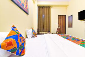 a bedroom with two beds and a flat screen tv at GMI Hotel and Benquet Jaipur in Jaipur