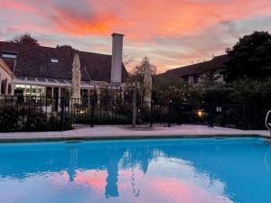 a blue swimming pool in front of a house at Appartementen De Torenhoeve in Burgh Haamstede
