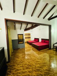 a bedroom with two red beds in a room at SkyLark Guest House in Nawalapitiya