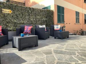un gruppo di sedie e tavoli in vimini su un patio di Affittacamere Il Veliero a Levanto