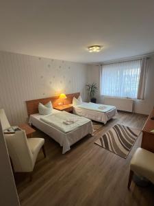 a hotel room with two beds and a chair at Reitanlage Plath in Timmendorf