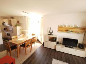 a living room with a dining room table and a television at Ferienhaus Düwels Hus in Krummhörn