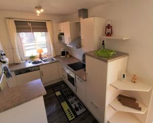 a kitchen with white cabinets and a counter top at Ferienhaus Düwels Hus in Krummhörn