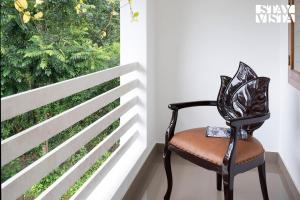 una silla sentada frente a una ventana en StayVista at Pine Escape - Breakfast Included en Pīrmed