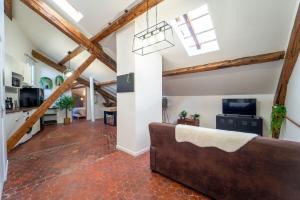 uma sala de estar com tectos em madeira e um sofá em Authentique studio hypercentre - clim - wifi em Nîmes