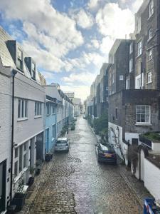 a street with cars parked on a cobblestone street at Delightful 2 Bedroom Apartment! in London