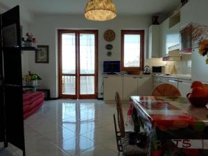 cocina con mesa y comedor en Ferienwohnung mit Balkon mit Meerblick und Autostellplatz, en Mascali