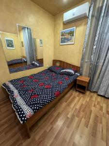 a bedroom with a bed with a comforter on it at TJ+ Hostel in Batumi