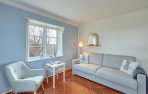 a living room with a couch and a chair at 2 Bedroom Lovely Home In Galmsbüll in Galmsbüll