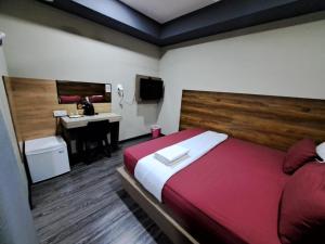 een slaapkamer met een bed en een bureau in een kamer bij Qing yun resthouse Bandar, Brunei Darussalam in Bandar Seri Begawan