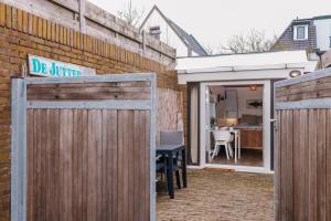 a patio with a wooden fence and a table at De Jutter - Zandvoort in Zandvoort