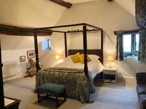 1 dormitorio con cama con dosel y silla en Riber Hall Manor en Matlock Bank