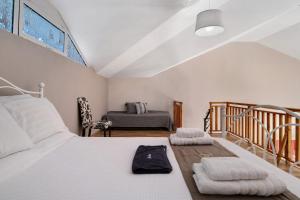 een slaapkamer met een wit bed en een trap bij Kouteris in Lygia