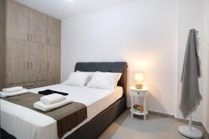 una camera da letto con un letto con lenzuola e asciugamani bianchi di Oceanida Sofia Luxury Suite a Nikiana