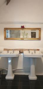two white sinks in a bathroom with a mirror at Riber Hall Manor in Matlock Bank