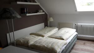 ein Bett in einem Schlafzimmer neben einem Fenster in der Unterkunft Charmantes Appartement in Sankt Peter-Ording mit Garten und Terrasse in Böhl