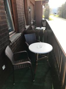 2 Tische und Stühle auf dem Balkon in der Unterkunft Hotel Faller in Breitnau