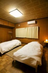 a room with two beds in it with a light at Roopt仙台薬師堂 in Sendai