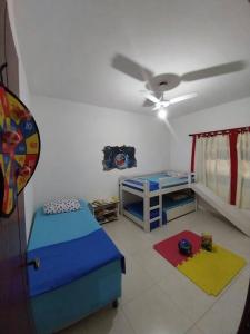 Habitación con 2 camas y ventilador de techo. en Casa ampla, arejada, muitos jogos e quarto cinema!, en Rio das Ostras