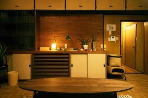 仙台的住宿－Roopt仙台薬師堂，一间设有桌子和书桌的柜台的房间
